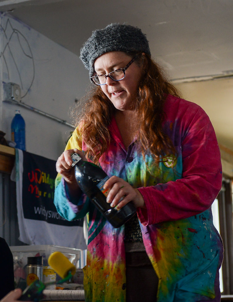 Stacy Self mixes paint for volunteers to use